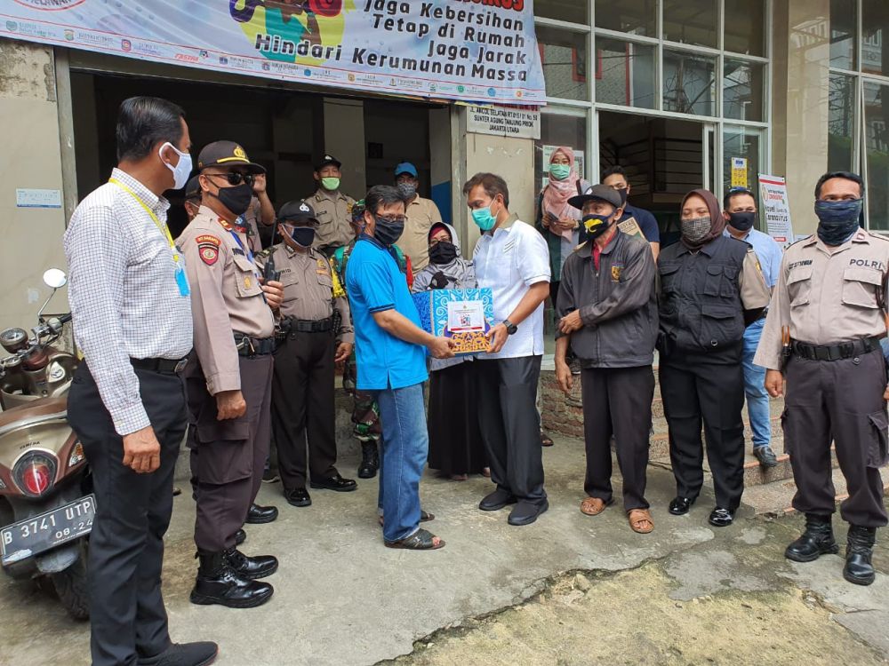 Direktur Ekonomi Baintelkam Mabes Polri Brigjen Pol Bayu Wisnumurti saat memberikan bantuan paket sembako pada warga di Jakarta Utara, Selasa (14/4/2020)